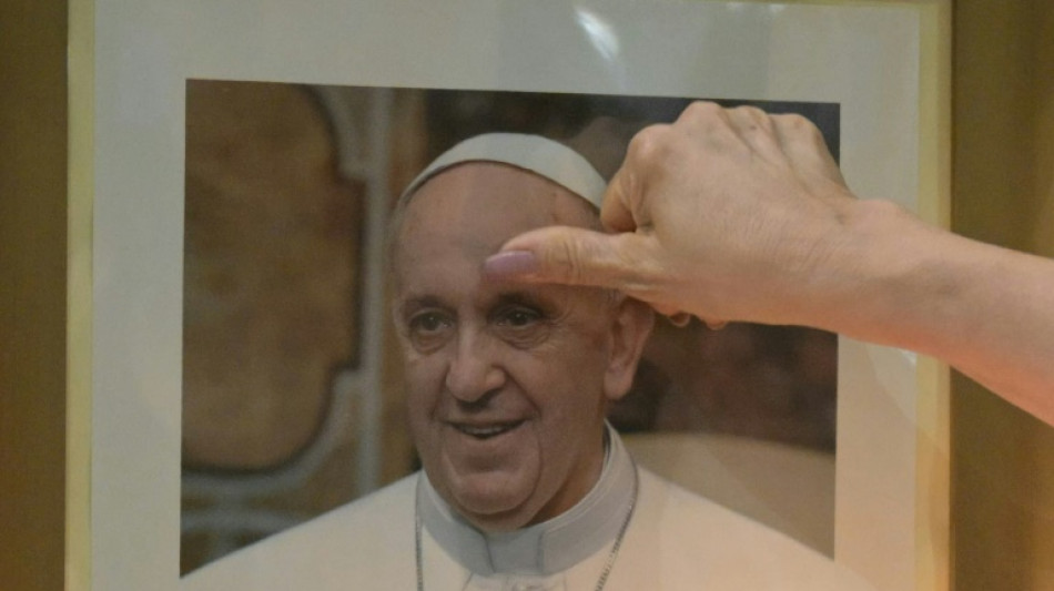 Pope 'sitting up, eating' in seventh day in hospital